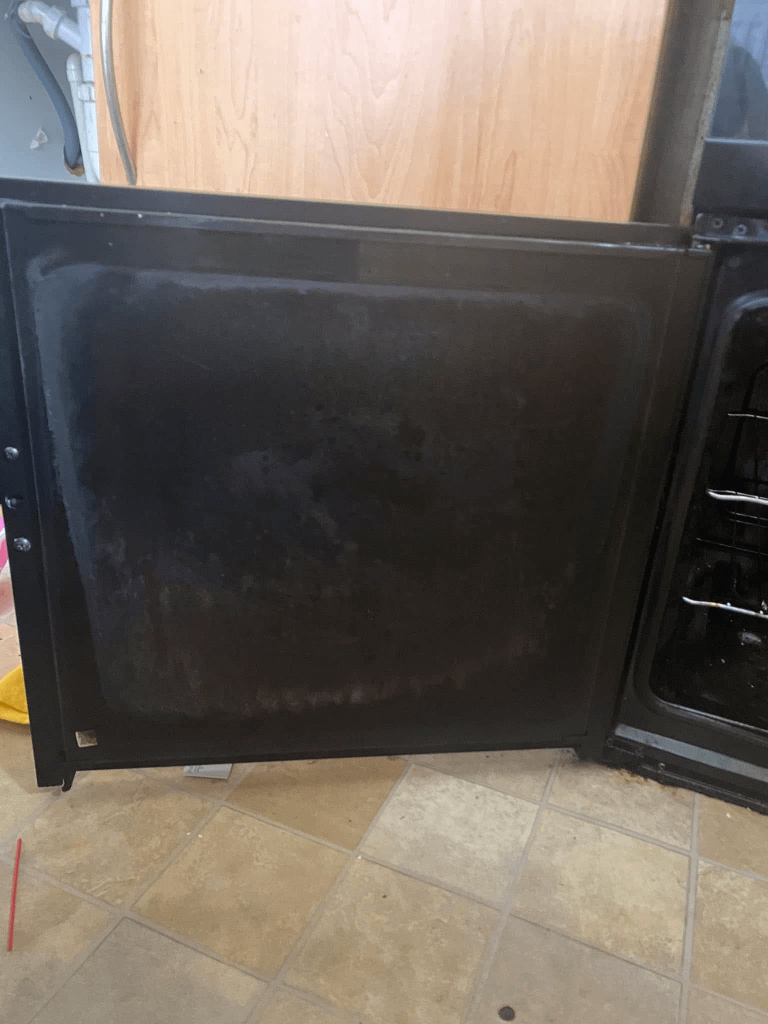 An oven door covered in grease and grime