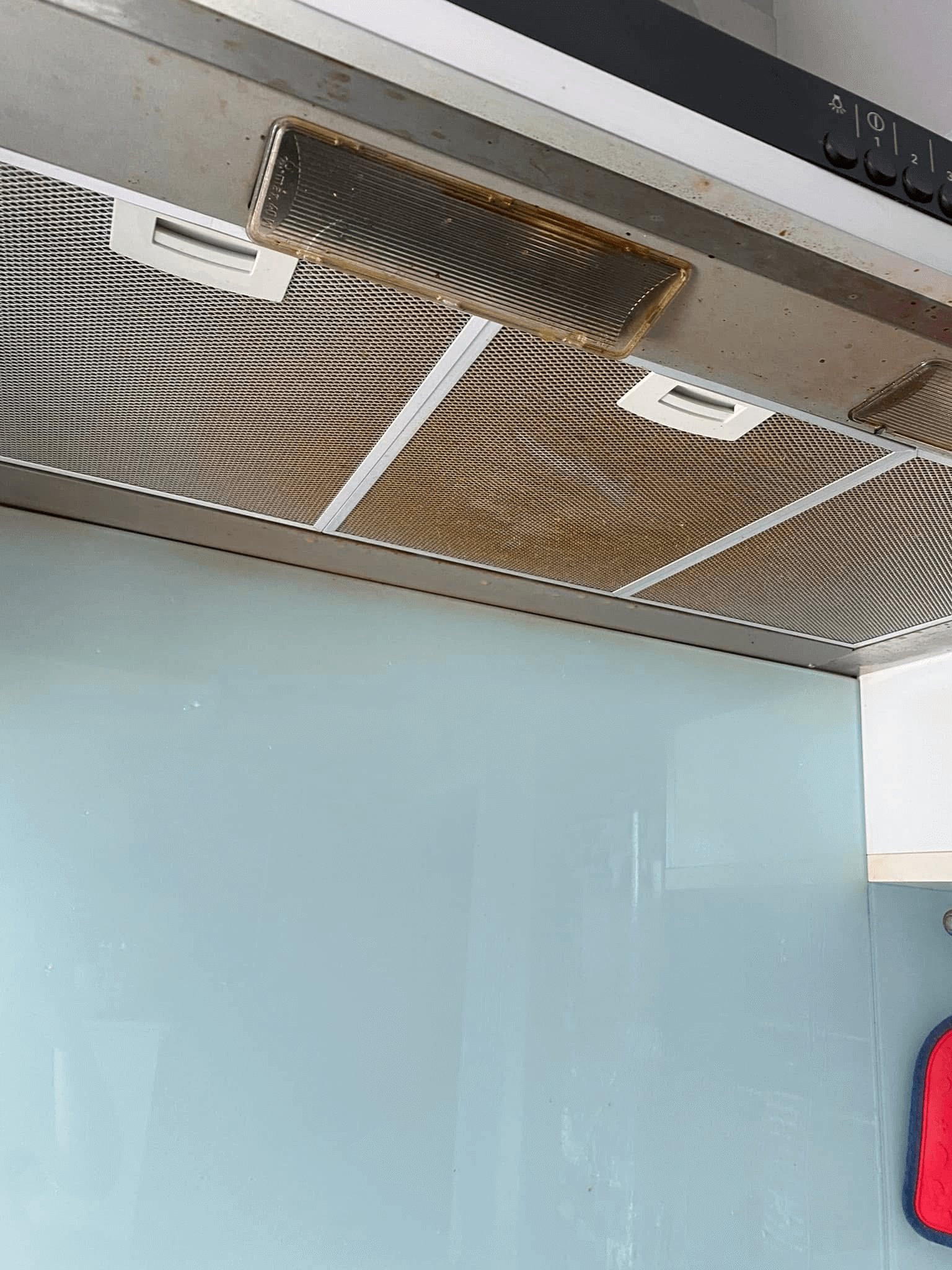 An oven hood covered in grease and grime